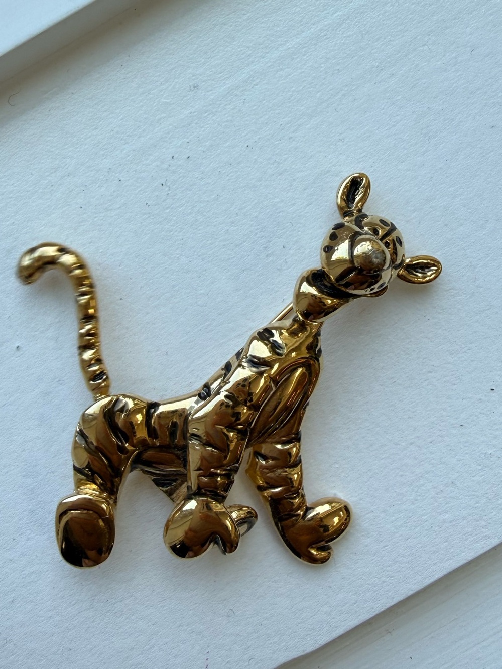 Vintage Disney Tigger brooch in gold with black stripes. Tail is articulated.